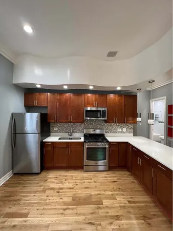 a large kitchen with stainless steel appliances granite countertop a stove a sink dishwasher and a refrigerator