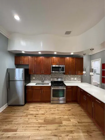 a large kitchen with stainless steel appliances granite countertop a stove a sink dishwasher and a refrigerator