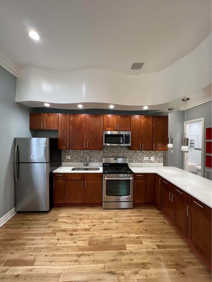 3100 West 39th Place Chicago, IL 60632 - Photo 32 of 36 a large kitchen with stainless steel appliances granite countertop a stove a sink dishwasher and a refrigerator