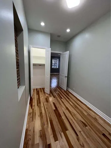 a view of a hallway with wooden floor and stairs