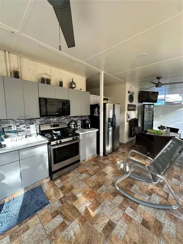a kitchen with stainless steel appliances kitchen island granite countertop a sink stove and refrigerator