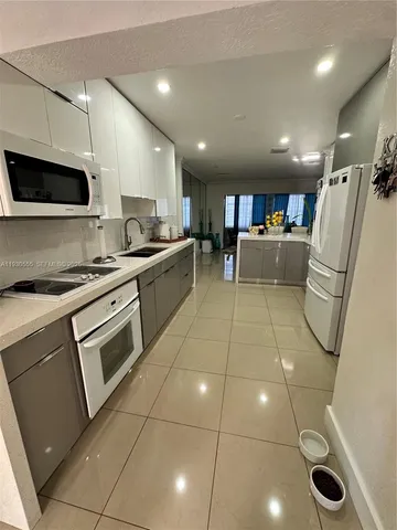 a kitchen with a sink a counter top space appliances and cabinets