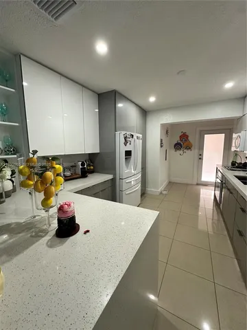 a large kitchen with stainless steel appliances granite countertop a stove a sink and a refrigerator