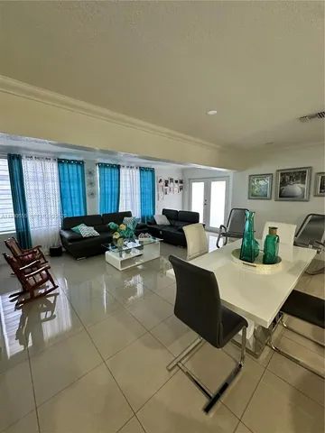 a large kitchen with a large counter top furniture a sink and stainless steel appliances