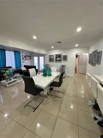 a living room with furniture a rug and a view of kitchen
