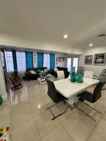a living room with furniture a large window and kitchen view