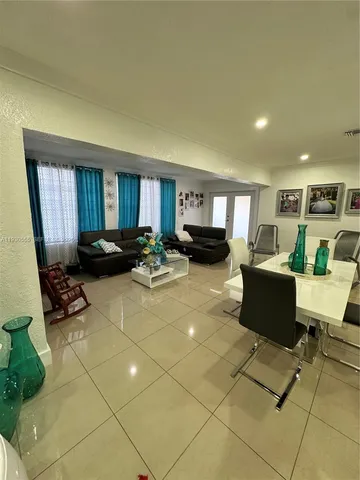a living room with furniture and a black white checkered floor with a large window