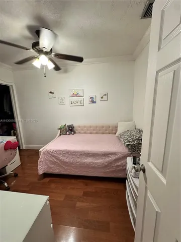 a bed room with a bed mirror and a chandelier