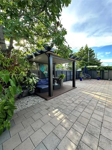 a living room with patio furniture and a potted plants