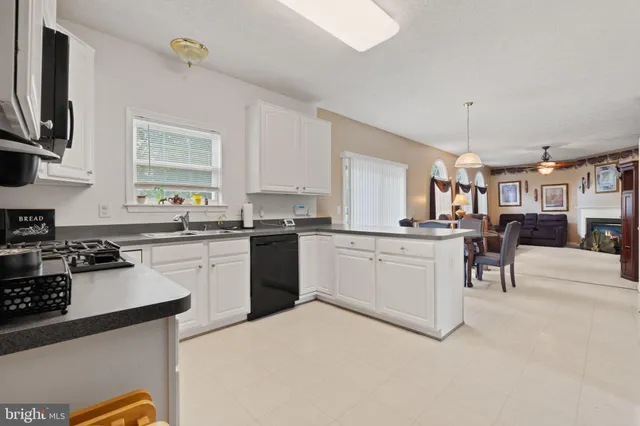 a kitchen with granite countertop white cabinets and white appliances