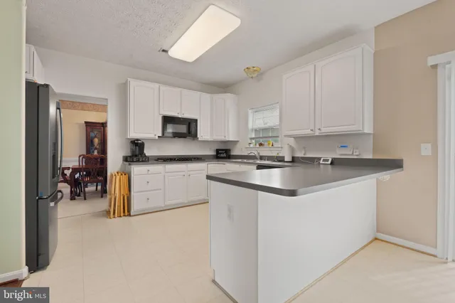 a kitchen with stainless steel appliances granite countertop a sink a stove and cabinets