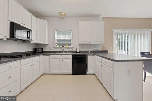 a kitchen with granite countertop white cabinets and stainless steel appliances