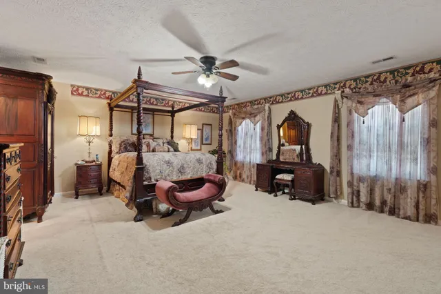 a spacious bedroom with a bed and a television