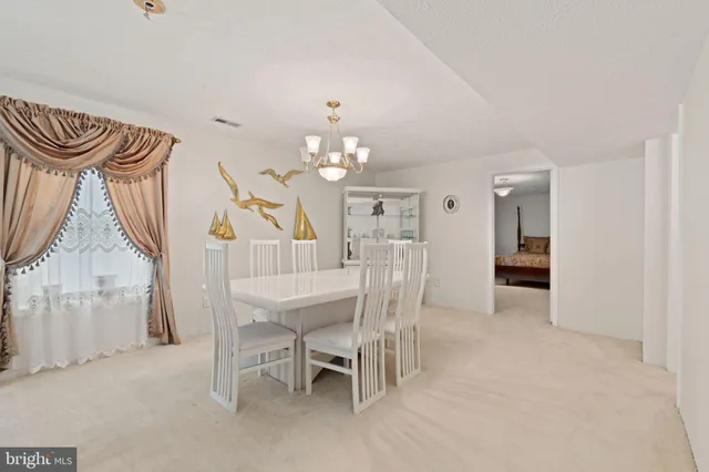 a living room with furniture a dining table and a chandelier