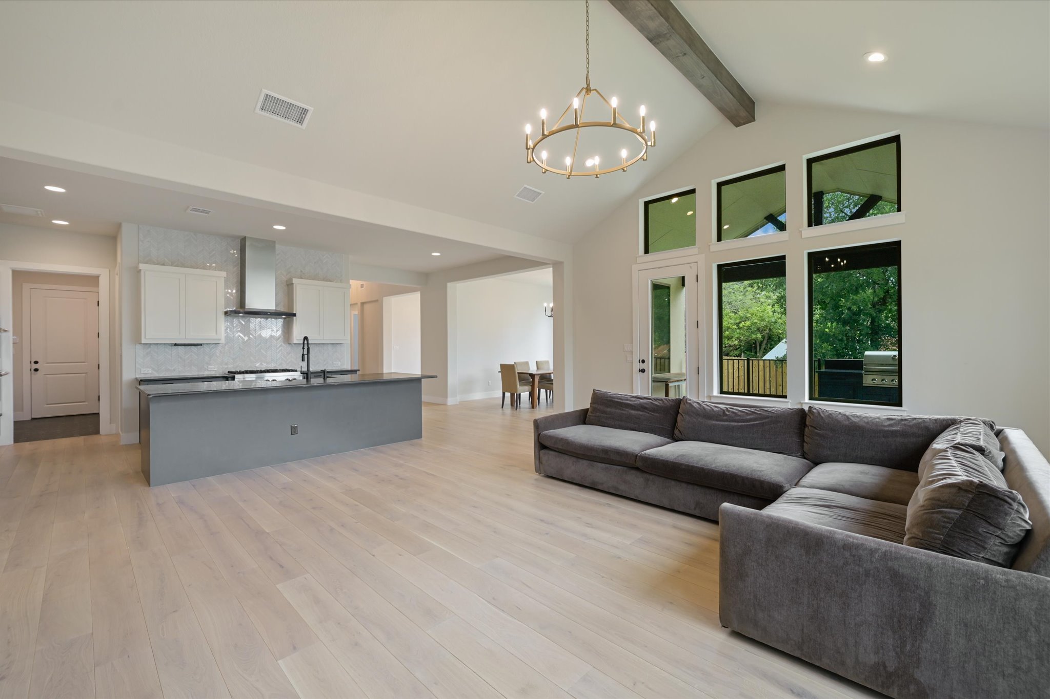 913 Presa Arriba Road Austin, TX 78733 - Photo 5 of 30 An open-concept living area with vaulted ceilings and abundant natural light from large windows.