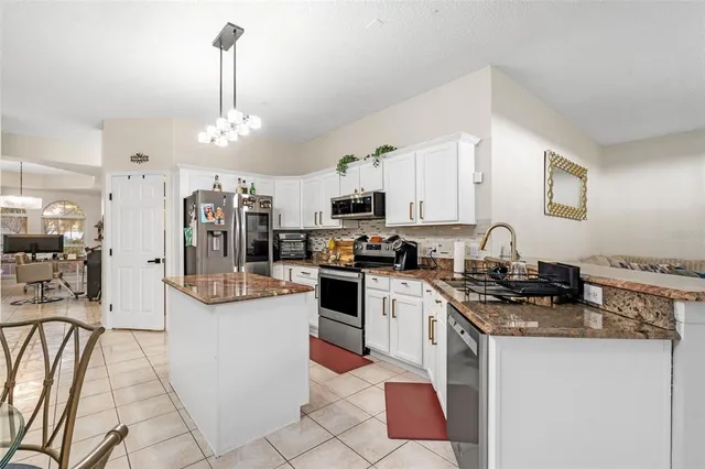 a kitchen with granite countertop a sink stove and cabinets