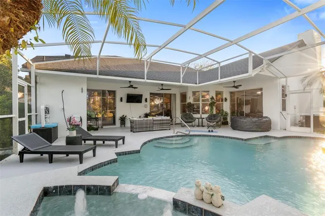 a view of a swimming pool with a garden and palm trees