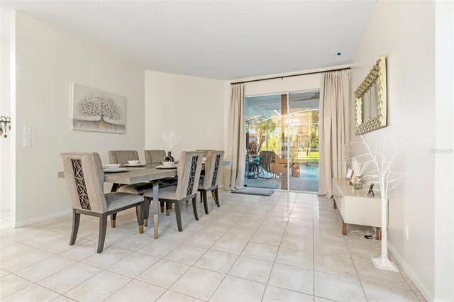a dining room with furniture and a floor to ceiling window