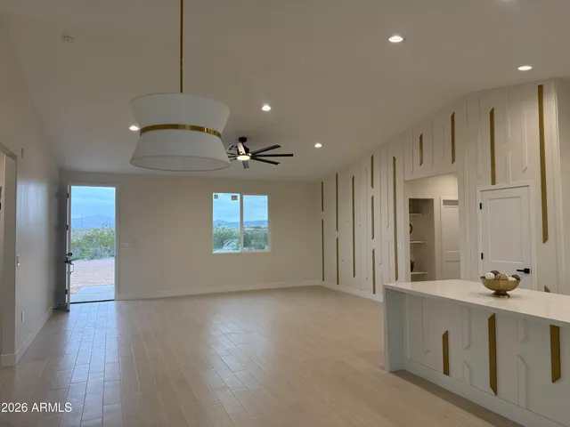 an empty room with a window and a fan