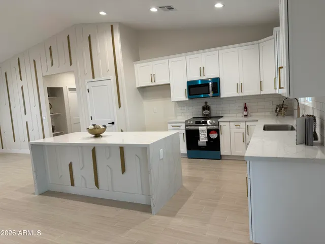 a large kitchen with cabinets and stainless steel appliances