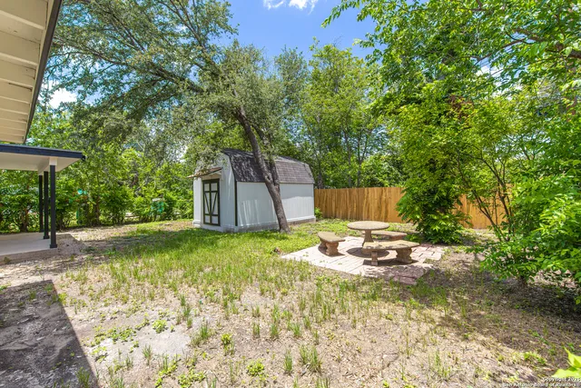 a backyard of a house with table and chairs