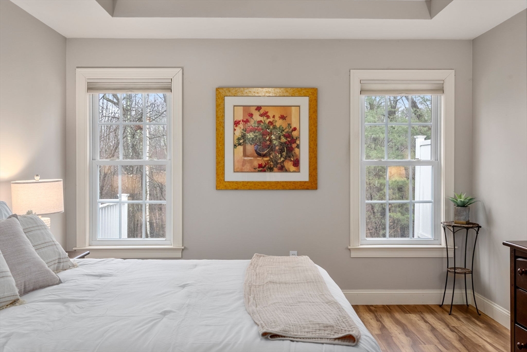 156 Canterbury Way, Unit 156 West Springfield, MA 01089 - Photo 17 of 32 a bedroom with a bed and wooden floor