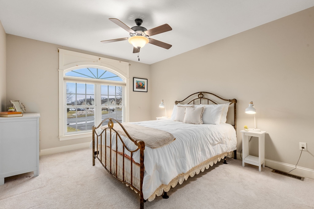 156 Canterbury Way, Unit 156 West Springfield, MA 01089 - Photo 21 of 32 a bedroom with a bed and a chandelier
