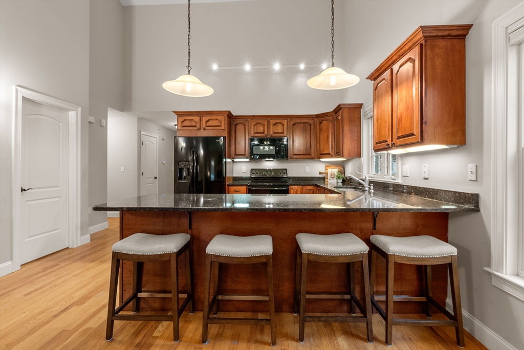 156 Canterbury Way, Unit 156 West Springfield, MA 01089 - Photo 4 of 32 a kitchen with granite countertop a table chairs stove a sink and dishwasher