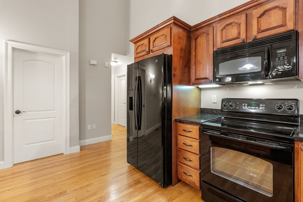 156 Canterbury Way, Unit 156 West Springfield, MA 01089 - Photo 7 of 32 a kitchen with stainless steel appliances granite countertop a stove microwave and refrigerator