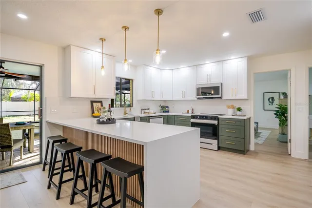 a kitchen with kitchen island granite countertop a sink counter top space appliances and cabinets