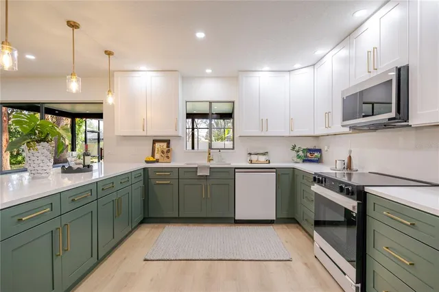 a kitchen with cabinets appliances and a window