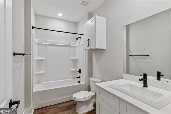 a bathroom with a sink a toilet and a large mirror