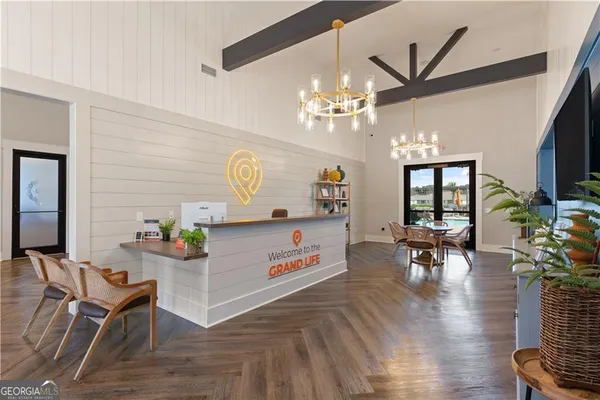 a view of a livingroom with furniture a chandelier and wooden floor