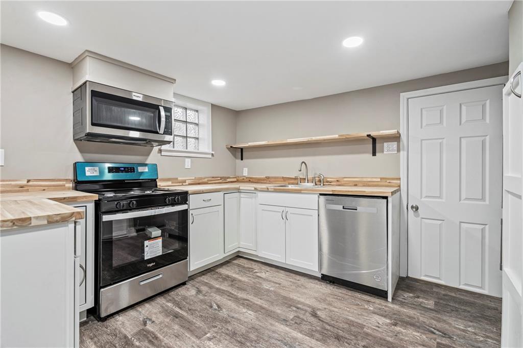 2215 Lehigh Street Pittsburgh, PA 15218 - Photo 19 of 32 a kitchen with stainless steel appliances granite countertop a stove a sink and a microwave