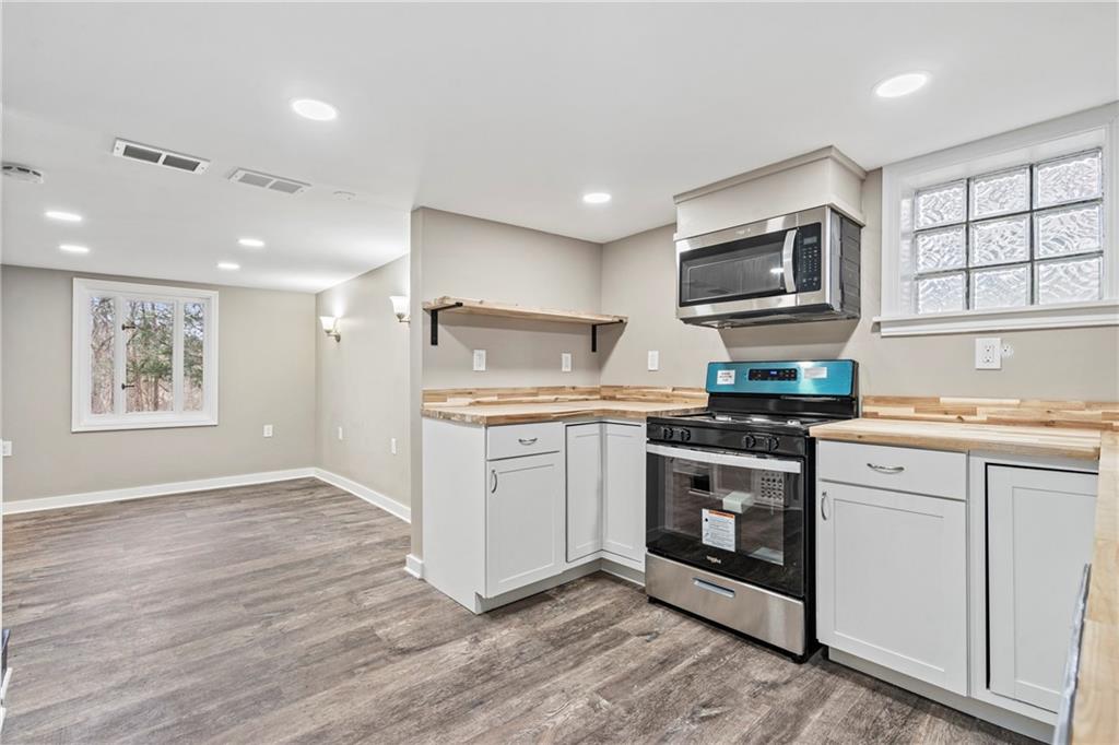 2215 Lehigh Street Pittsburgh, PA 15218 - Photo 21 of 32 a kitchen with kitchen island granite countertop a stove cabinets and microwave
