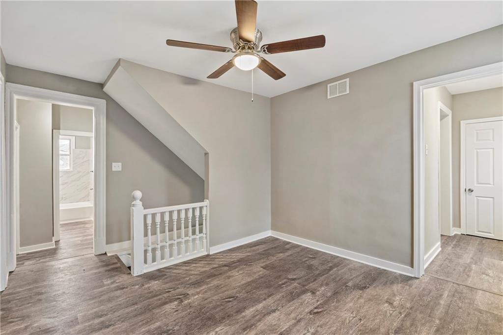 2215 Lehigh Street Pittsburgh, PA 15218 - Photo 7 of 32 a view of a hallway with wooden floor and a ceiling fan