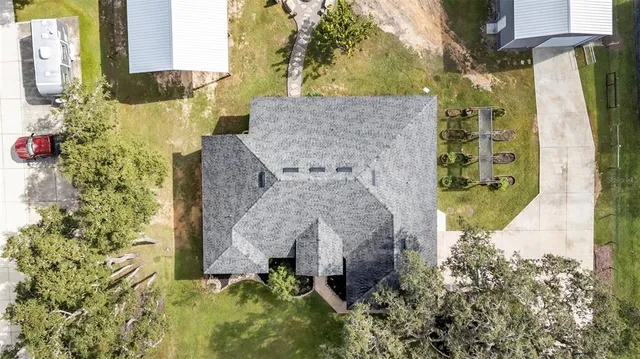 a aerial view of a house with a yard and large trees