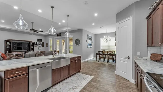 a kitchen with granite countertop a table chairs microwave and refrigerator