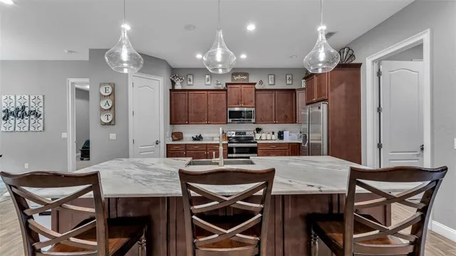 a kitchen with stainless steel appliances granite countertop a sink stove and refrigerator