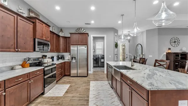 a living room with furniture kitchen view and a chandelier