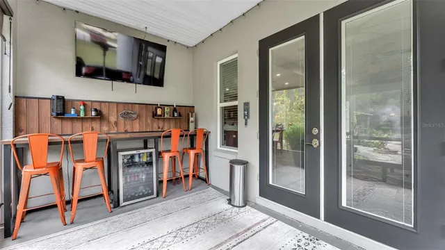 a view of a patio with table and chairs with wooden floor and fence