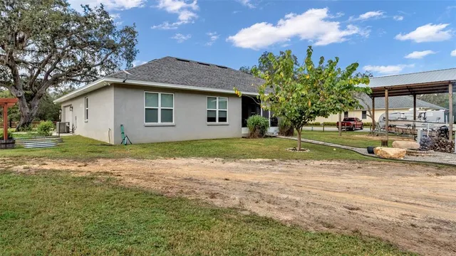 an aerial view of residential house with outdoor space and trees all around