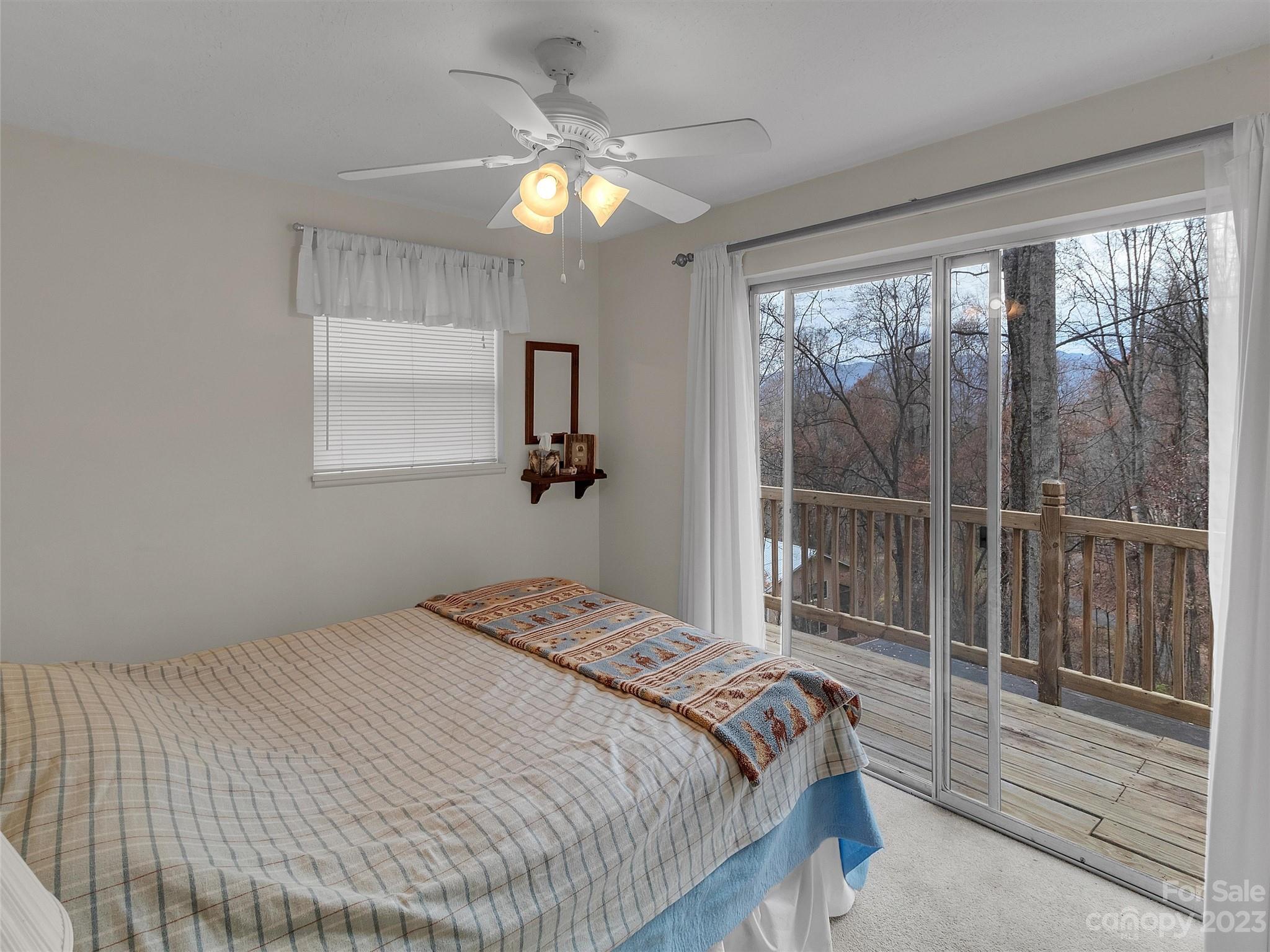645 Mouzon Road Waynesville, NC 28785 - Photo 19 of 40 a bedroom with a large bed and a chandelier