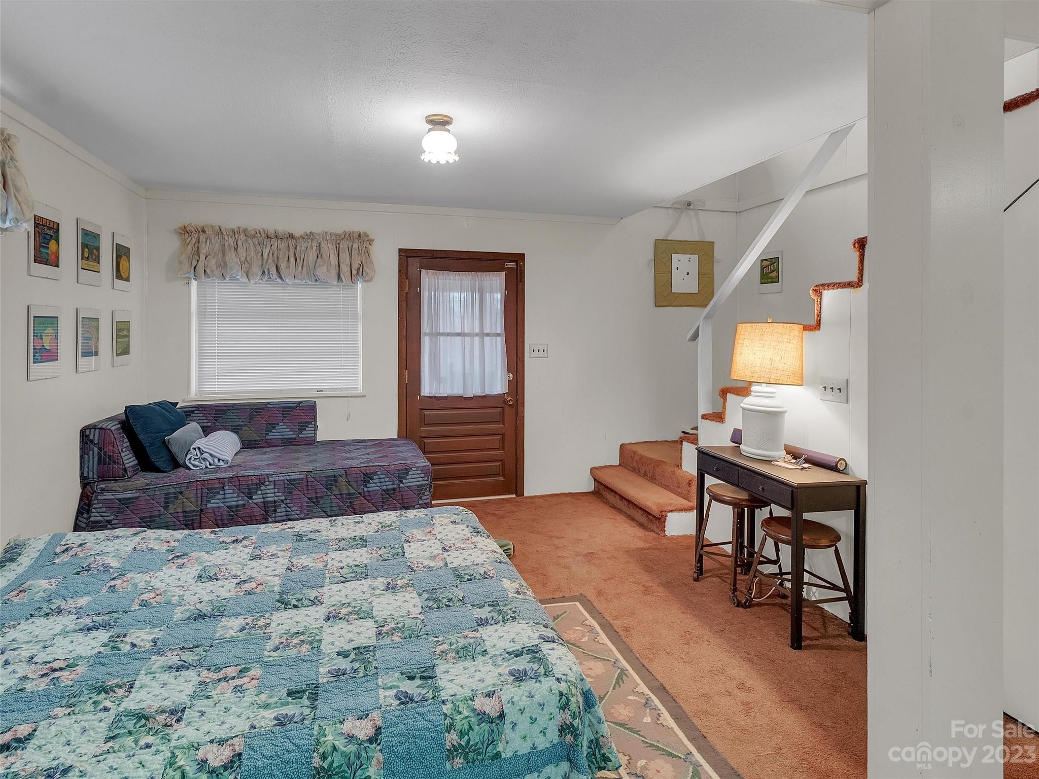 645 Mouzon Road Waynesville, NC 28785 - Photo 33 of 40 a spacious bedroom with a bed and a table in it