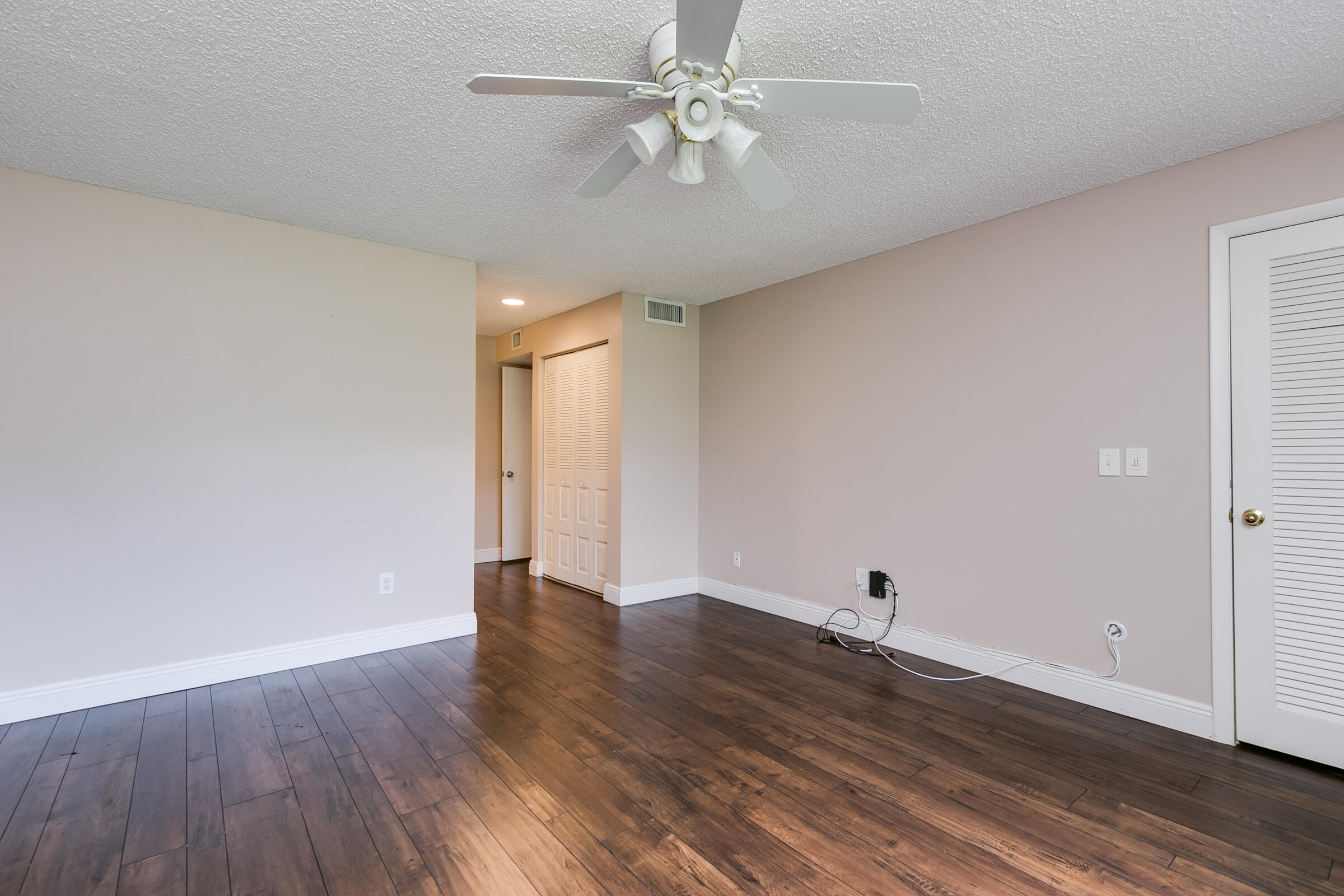 8535 Casa Del Lago, Unit 37E Boca Raton, FL 33433 - Photo 23 of 39 an empty room with wooden floor and fan