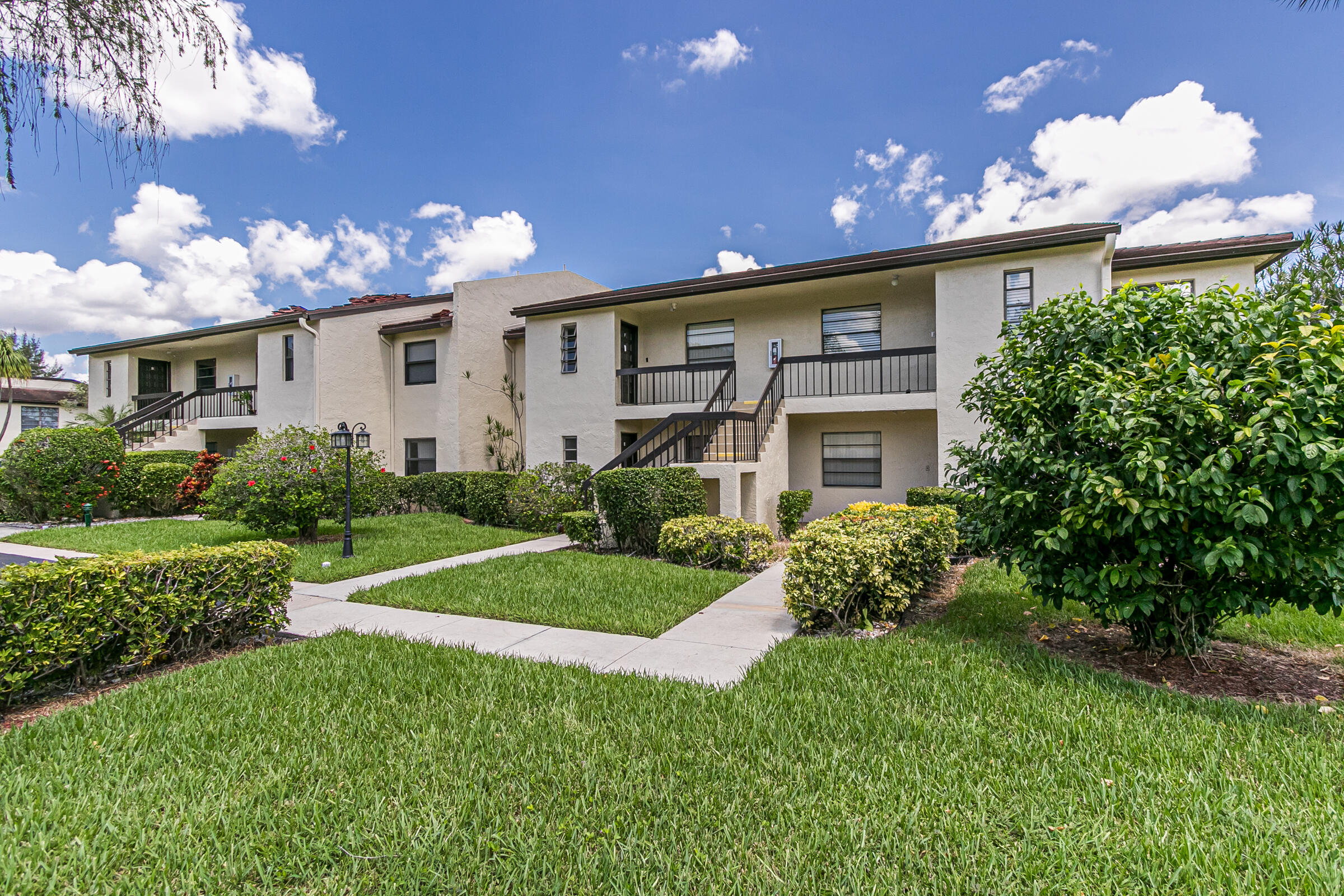 8535 Casa Del Lago, Unit 37E Boca Raton, FL 33433 - Photo 4 of 39 a front view of a house with a yard and outdoor seating