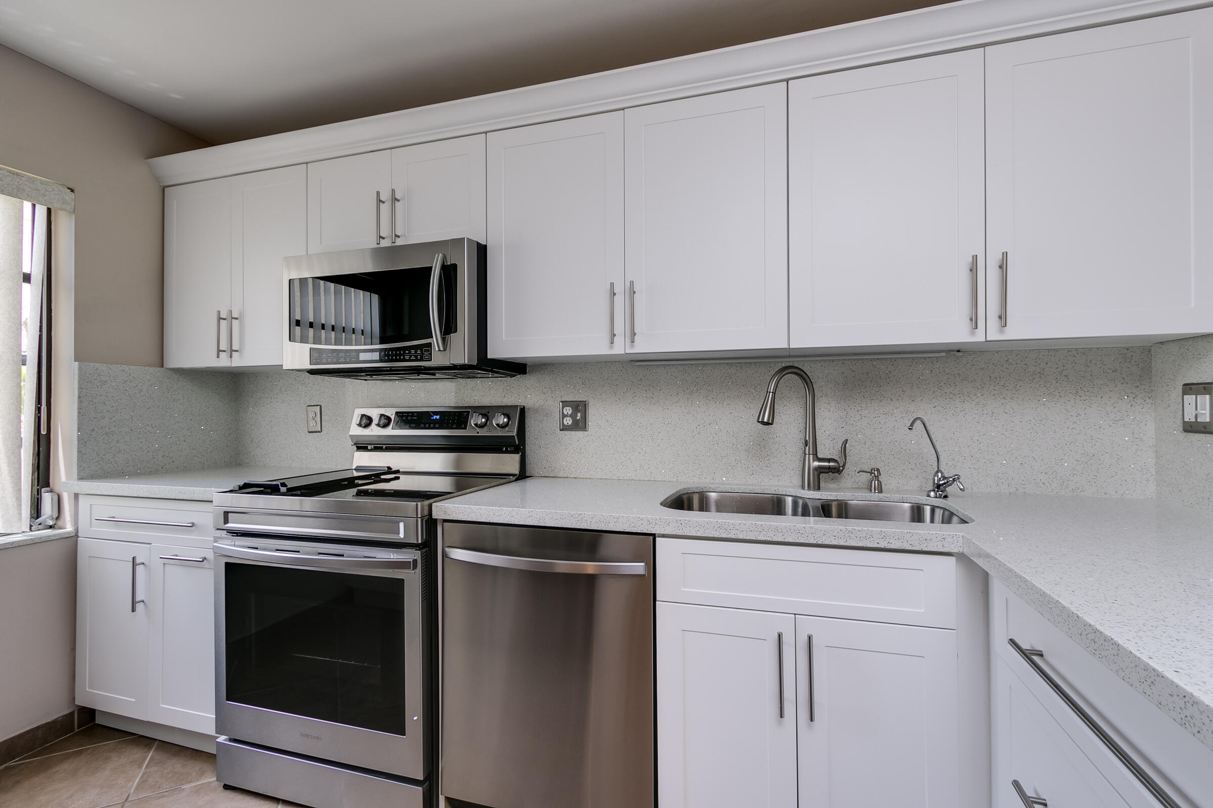 8535 Casa Del Lago, Unit 37E Boca Raton, FL 33433 - Photo 7 of 39 a kitchen with cabinets appliances a sink and a counter top
