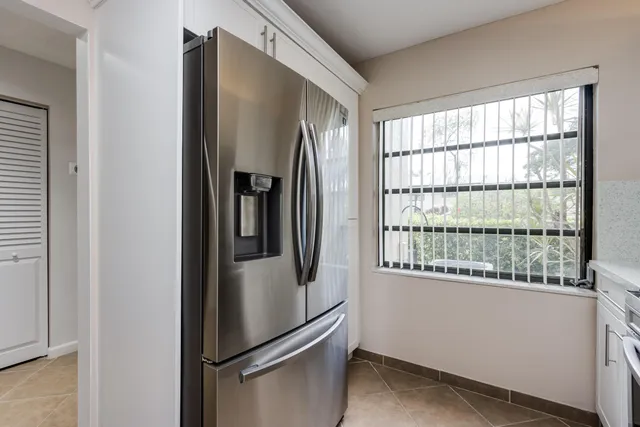 a metallic refrigerator freezer sitting in a kitchen
