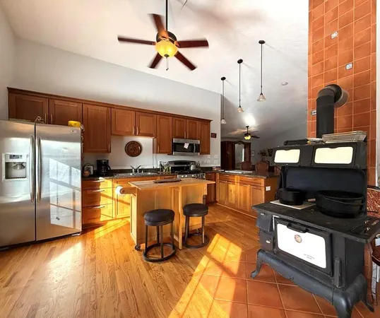 a kitchen with stainless steel appliances granite countertop a stove a sink a refrigerator and a microwave