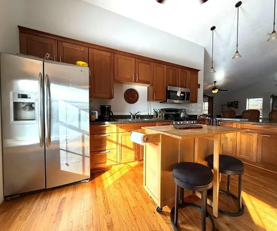 a kitchen with stainless steel appliances granite countertop a refrigerator a sink and a stove
